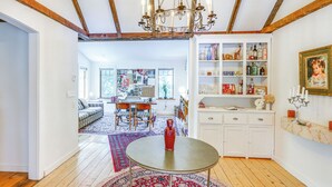 A spacious living area with a chandelier, wooden beams, a dining table, and a red vase. - 9 Mi to Dtwn Hudson: Pet-friendly Home w/ Pool (Craryville)