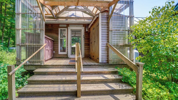 A wooden staircase leading to a covered porch with a wooden railing. - 9 Mi to Dtwn Hudson: Pet-friendly Home w/ Pool (Craryville)