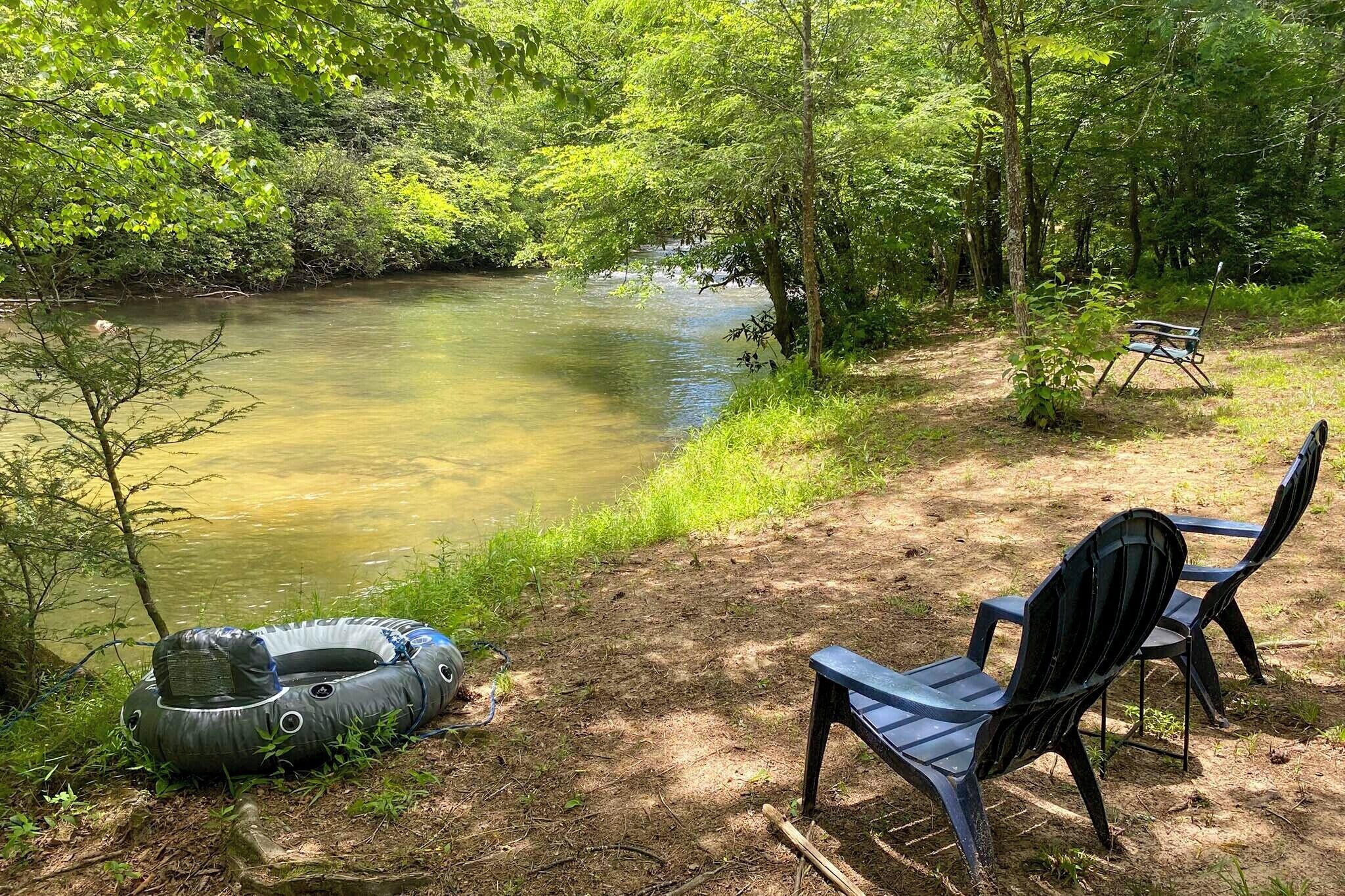Een natuurlijke omgeving met een rivier, een drijvend ringetje en twee stoelen.