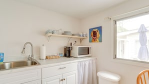 A small kitchenette with a sink, microwave, and shelves above. - Walk to Norfork Lake: Guest House in Henderson (Henderson)