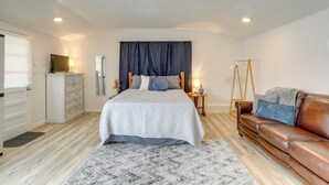 A bedroom with a bed, a dresser, a vanity, a sofa, and a wooden ladder. - Walk to Norfork Lake: Guest House in Henderson (Henderson)