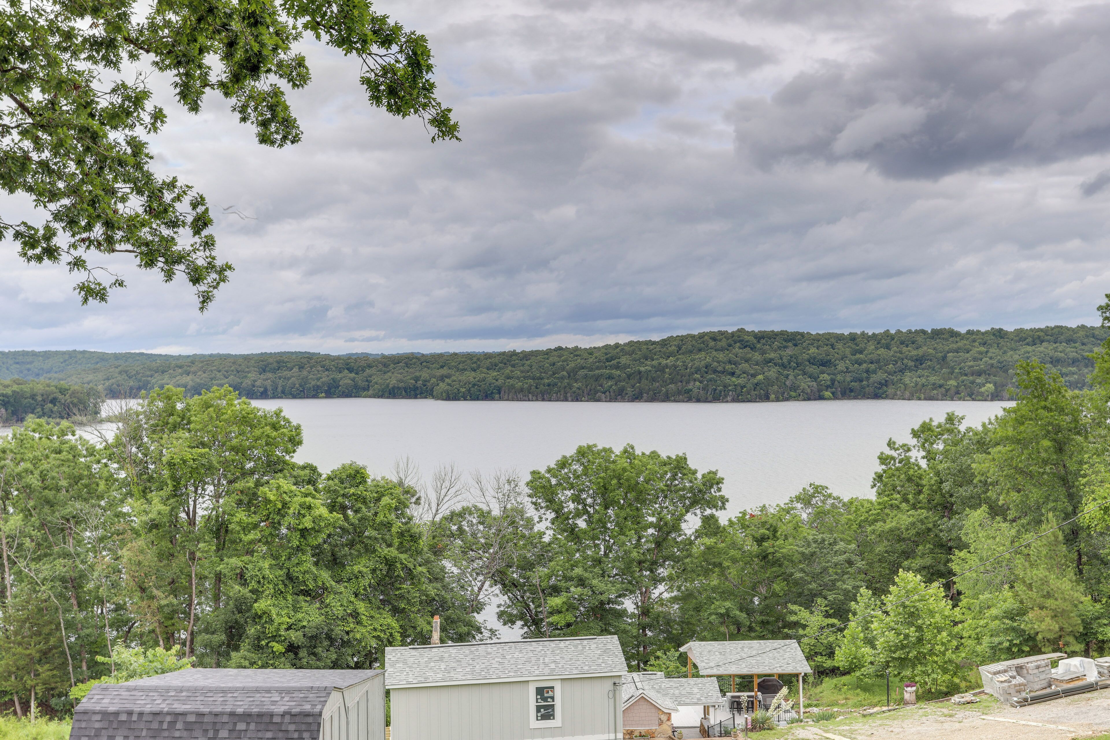 A lakeside cabin with a view of the lake and forested hills.