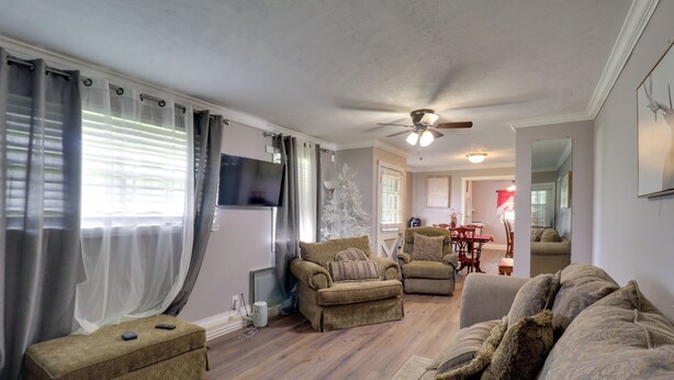 A living room with a sofa set, a coffee table, and a television. - 16 Mi to Dtwn Jackson: Quiet Southern Escape (Terry)