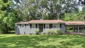 A single-story house with a covered porch, a fenced yard, and a well-maintained lawn. - 16 Mi to Dtwn Jackson: Quiet Southern Escape (Terry)