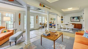 A spacious living room with a large window, a wooden coffee table, and a bright, airy atmosphere. - Fire Pit + Ping-pong: Home on Guadalupe River! (Seguin)