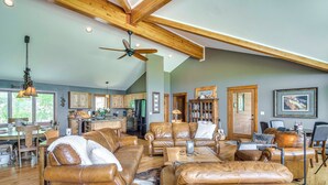A spacious living room with leather sofas, a dining area, and a kitchen. - Private 5 Acres w/ Mtn Views: Park County Cabin! (Jefferson)