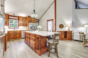 Una cocina amplia con armarios de madera, una isla grande y vistas al exterior.