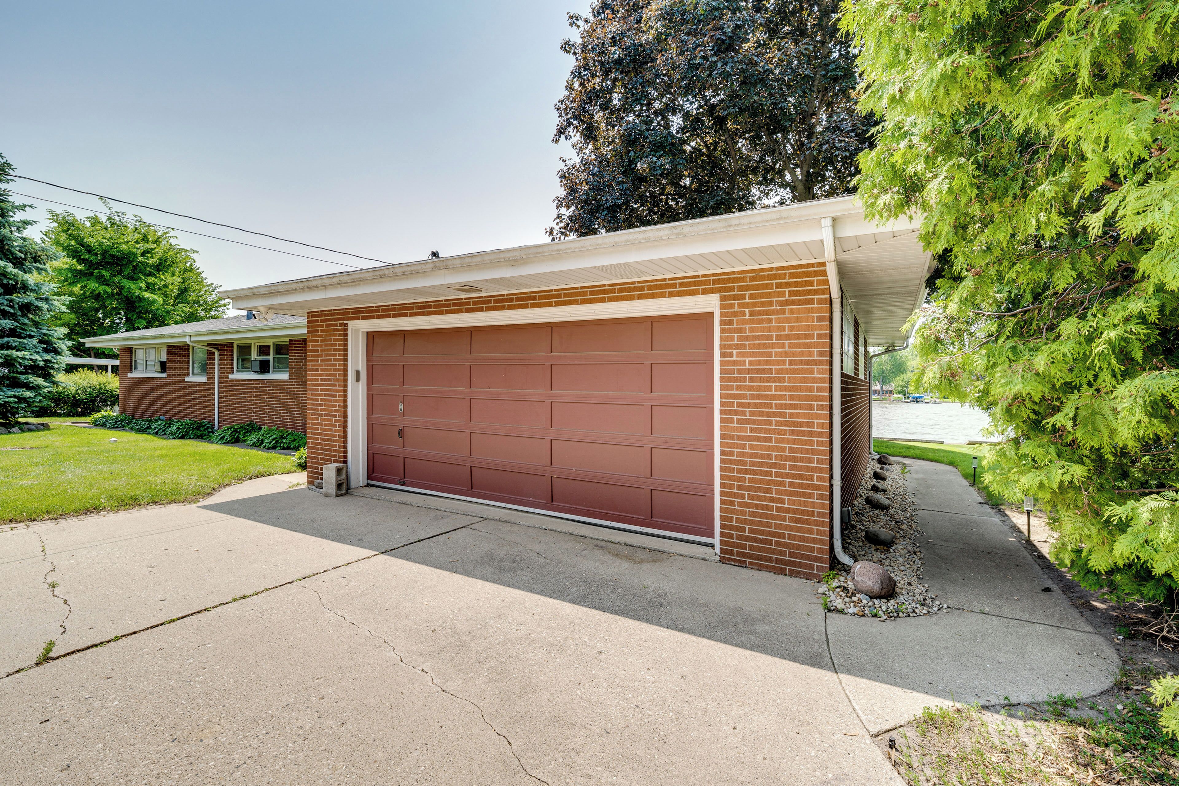 A single-story house with a garage, brick exterior, and a well-maintained lawn.