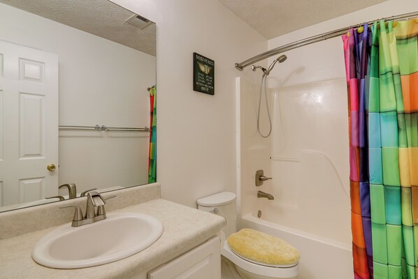 A bathroom with a sink, toilet, and bathtub. - Shop, Fish & Explore: Suburban Home in Loganville! (Loganville)