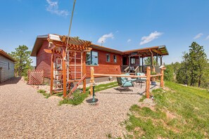 Une cabane en bois dotée d’un porche, d’un espace salon extérieur et d’une allée en gravier.