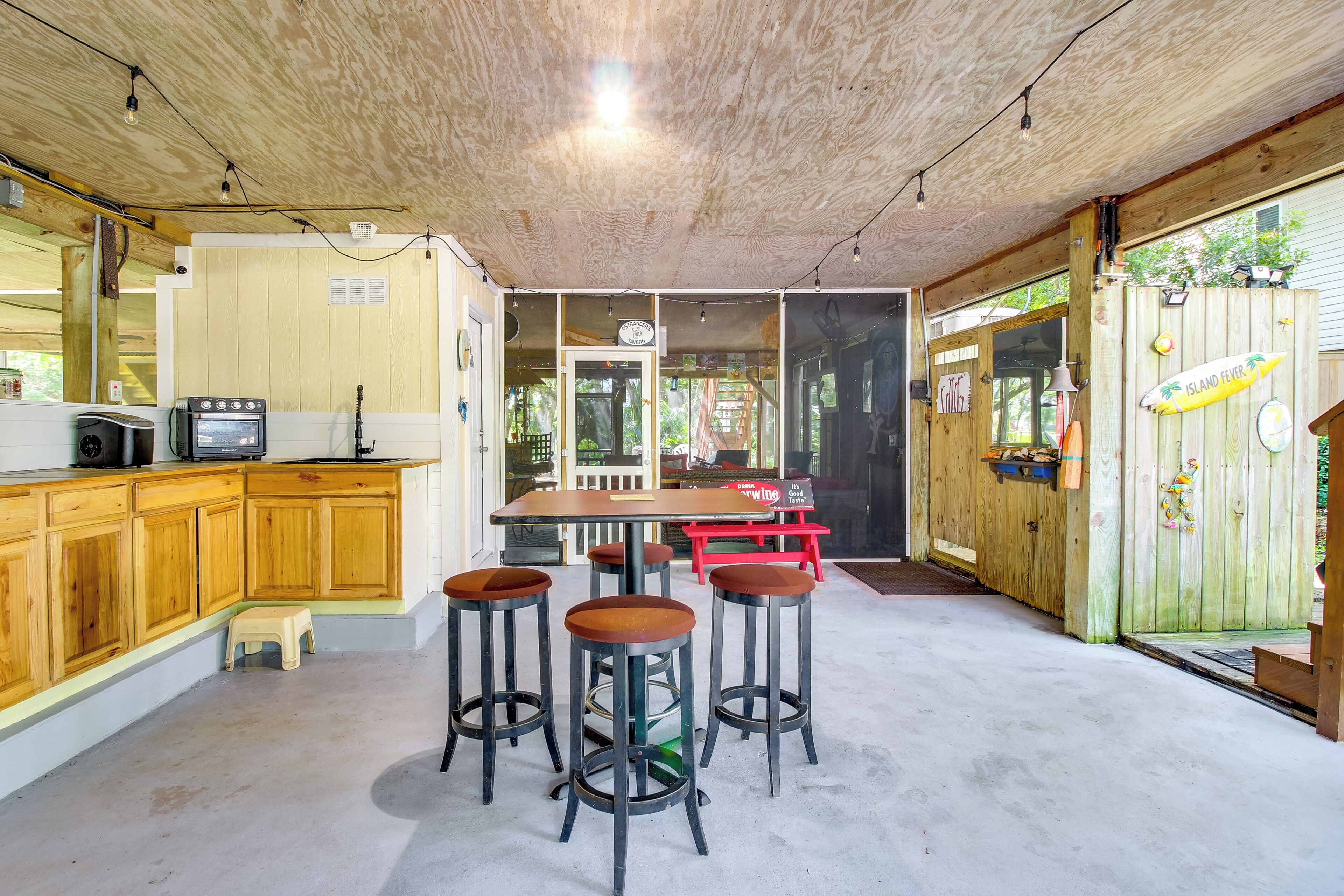 A kitchen with wooden cabinets, a bar area with stools, and a dining table.