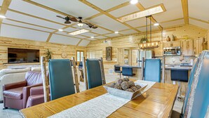 A spacious room with a wooden dining table, blue chairs, and a ceiling fan. - Walk to Shay Lake: Updated Home w/ Water View! (Silverwood)