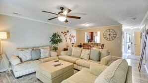 A spacious living room with a sectional sofa, a coffee table, and a ceiling fan. - 5 Mi to NAS Oceana: Townhome w/ Fenced Yard! (Virginia Beach)