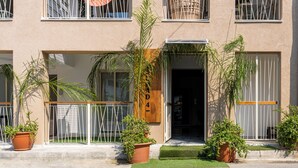 Un edificio con puerta de madera que tiene el número 4 y un balcón con barandilla metálica.