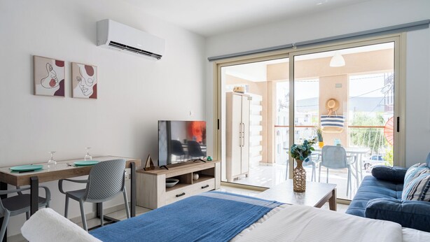 Una habitación de hotel moderna con cama, escritorio, televisión y balcón con vistas.