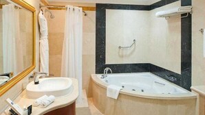 Een moderne badkamer met een vrijstaand bad, een wastafel en een grote spiegel.