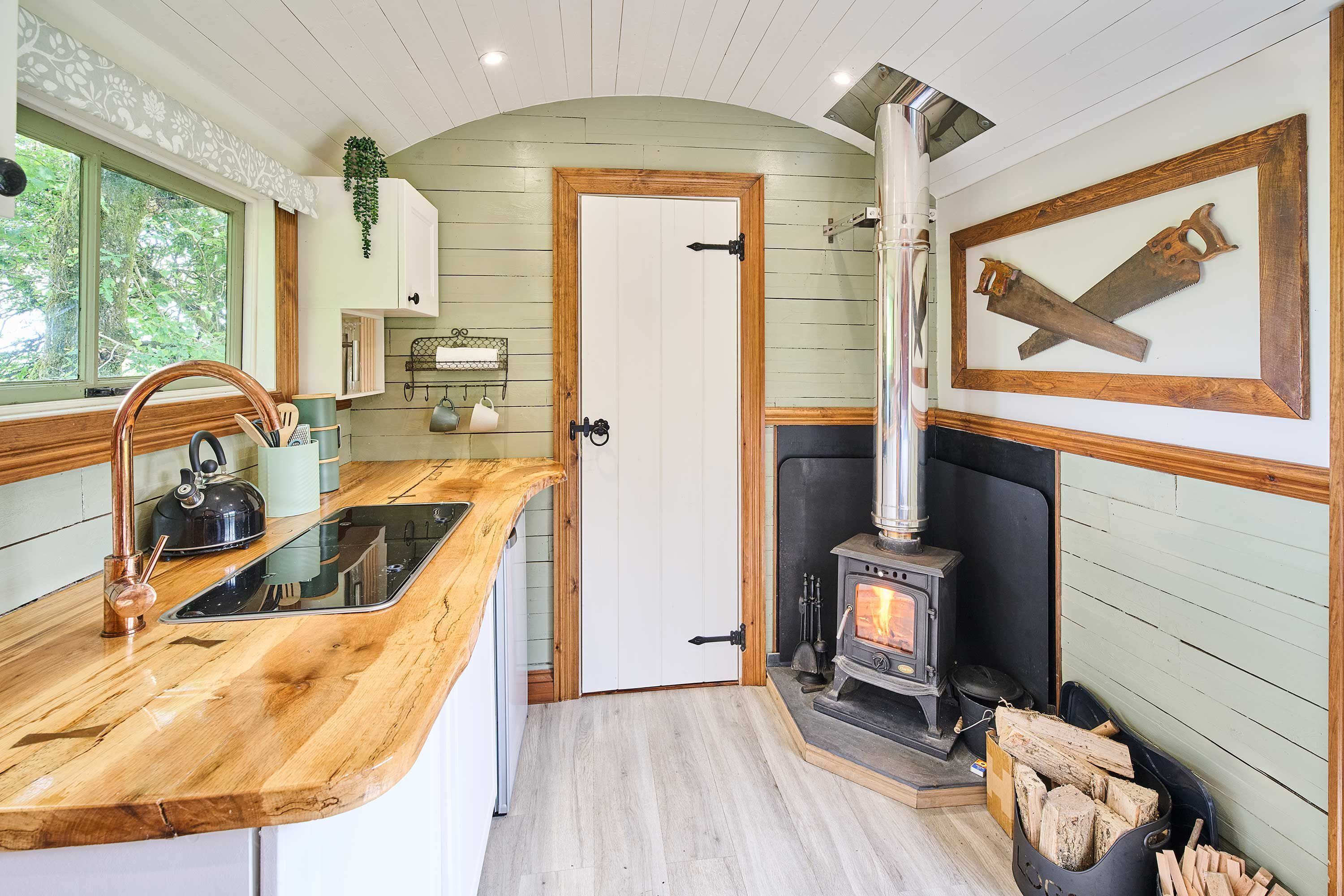 Una cocina acogedora con encimera de madera, estufa y una puerta que da a otra habitación.