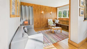 Una sala acogedora con un sofá gris, una mesita de madera y un tapete colorido.