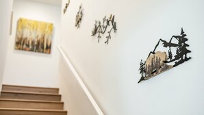 A staircase with a wall-mounted artwork depicting a forest scene. - Spacious 5BR Getaway w Game Room Modern Comfort (Fontana)