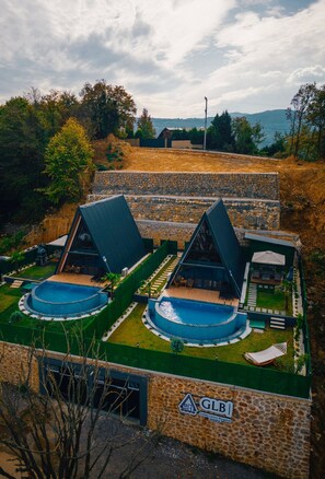 A modern villa with two large swimming pools, a stone exterior, and a view of the surrounding landscape. - glbsapanca (Sapanca)