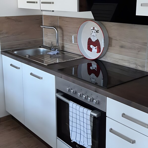 Een koelkast, een oven, een kookplaat, een vaatwasser