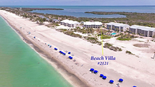 An aerial view of Beach Villa #2121 with a long beachfront, several buildings, and a clear view of the ocean. - Beach Villa 2121: Your Exclusive Two-Story Beach Villa with Direct Gulf Views (Captiva)