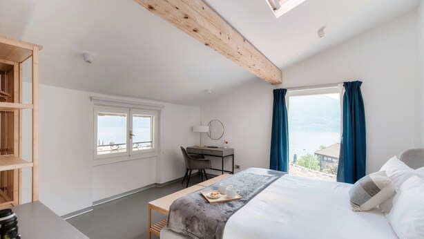Una camera da letto con un letto, una scrivania e vista sull'esterno.