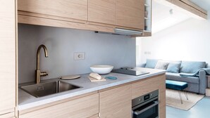 Una cucina moderna con mobili in legno, un lavello in acciaio inossidabile e una ciotola sul piano di lavoro.