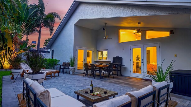 A patio with outdoor furniture, a dining area, and a ceiling fan.