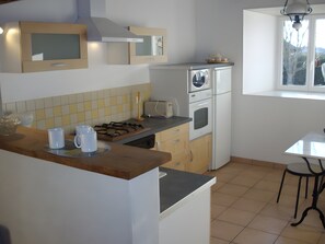 A kitchen with a gas stove, microwave, oven, and a window with a view.