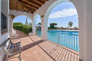 A covered outdoor area with a bench, a pool, and a view of the surrounding landscape. - Holiday Home 'Las Palmas' with Sea View, Wi-Fi and Air Conditioning (Nerja)