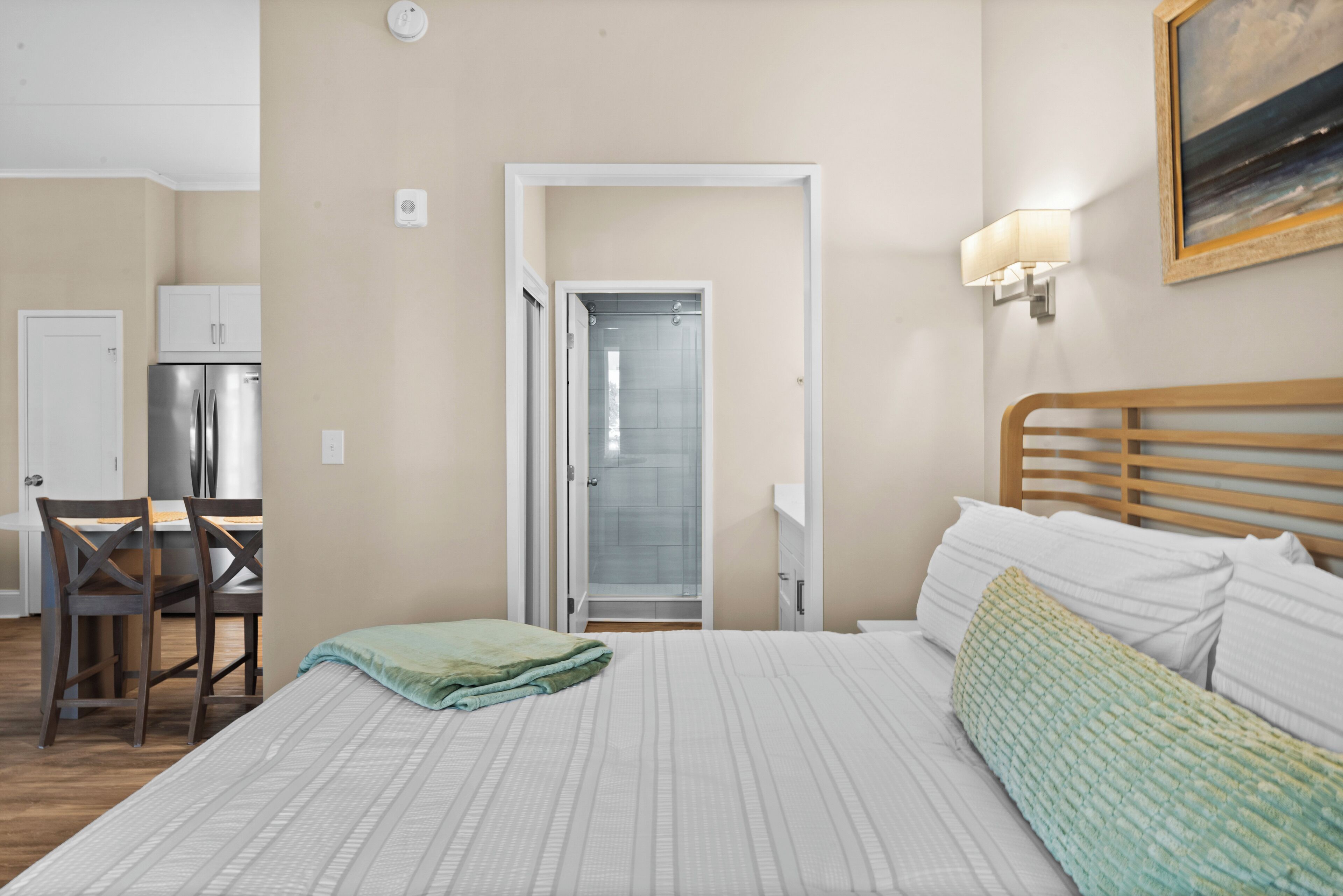 Hotellihuone, jossa on sänky, työpöytä ja suihku.