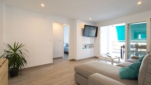 A modern living room with a sofa, a coffee table, and a potted plant. - Javea Apartment 300 meters from sandy beach and many bars/restaurants (javea)