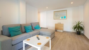 A modern living room with a grey sectional sofa, a white coffee table, and a potted plant. - Javea Apartment 300 meters from sandy beach and many bars/restaurants (javea)