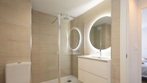 A modern bathroom with a glass-enclosed shower, a white toilet, and a vanity with a mirror. - Javea Apartment 300 meters from sandy beach and many bars/restaurants (javea)