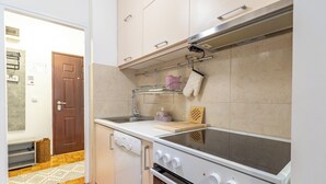 A compact kitchen with a stove, dishwasher, and a small countertop.