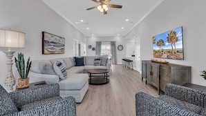 A modern living room with a sectional sofa, a coffee table, and patterned chairs.