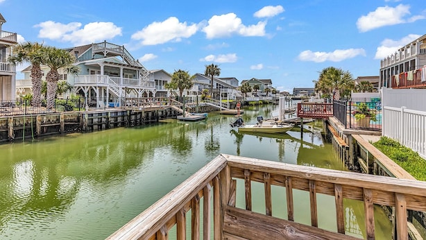 A waterfront property with a dock, a boat, and a canal.
