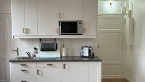 A modern kitchen with white cabinets, a microwave, a toaster, and a sink.