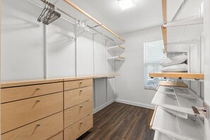 Un vestidor con cajones de madera, perchas metálicas y estantes.