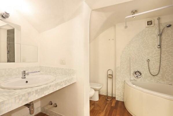 Casa de banho com lavatório, sanita e banheira.