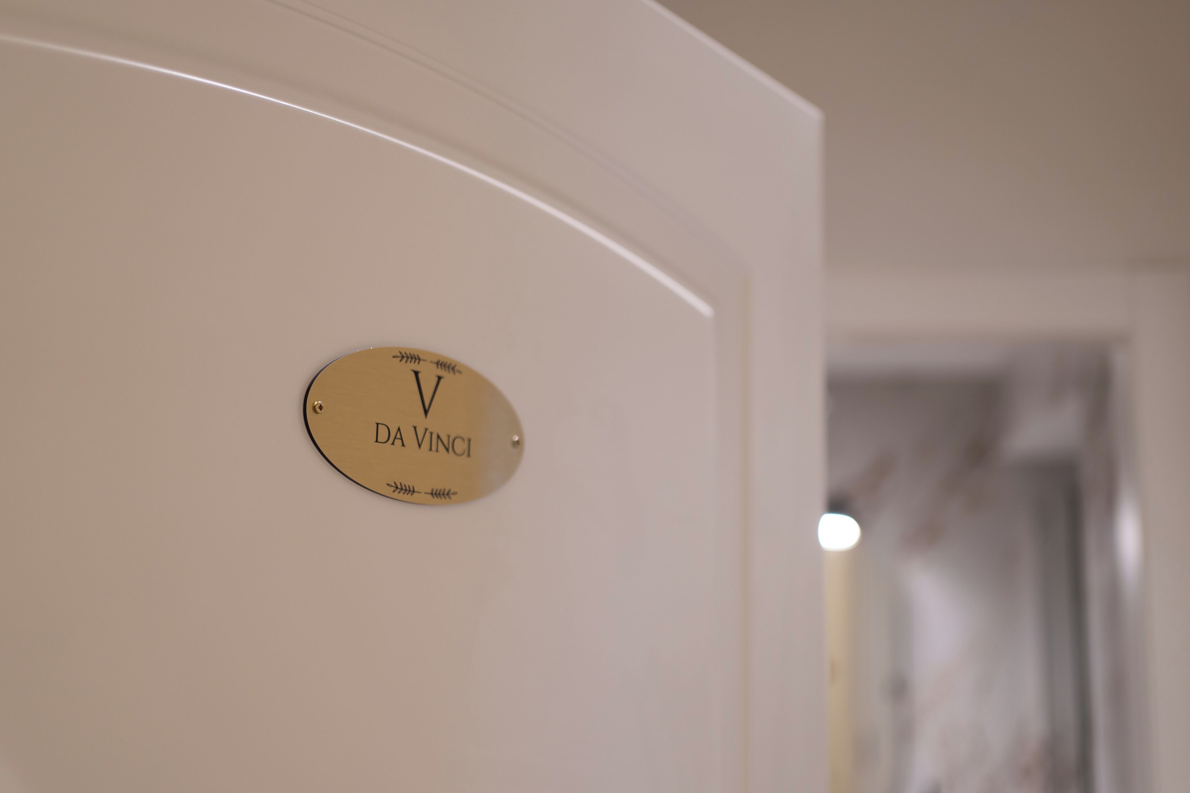 A gold plaque with "DA VINCI" on a white wall.