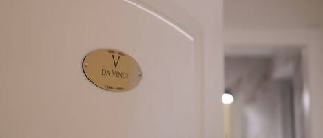 Una placa dorada con la inscripción "DA VINCI" sobre una pared blanca.