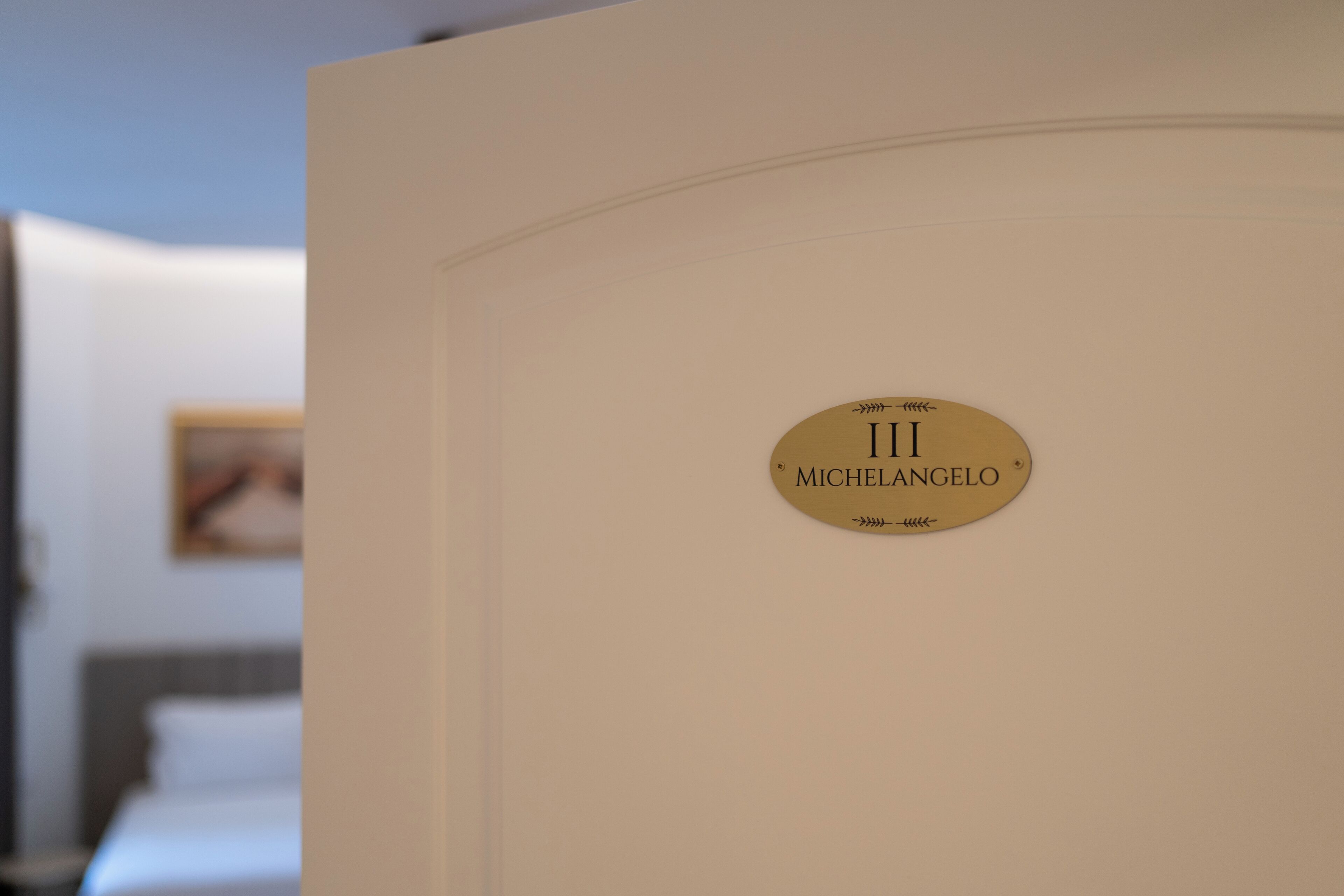 Ein Zimmer mit einem Bett und einem Schild mit der Aufschrift 'Michelangelo'.