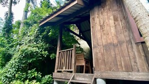 A wooden structure with a staircase leading to a covered area, surrounded by lush greenery. - Peaceful, air-conditioned jungle bungalow - less than 5mins from Lamai beach (Chang Wat Surat Thani)