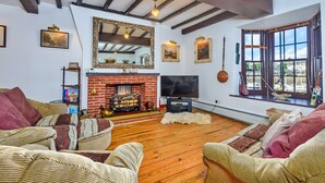 Una sala de estar acogedora con chimenea, pisos de madera y asientos cómodos.