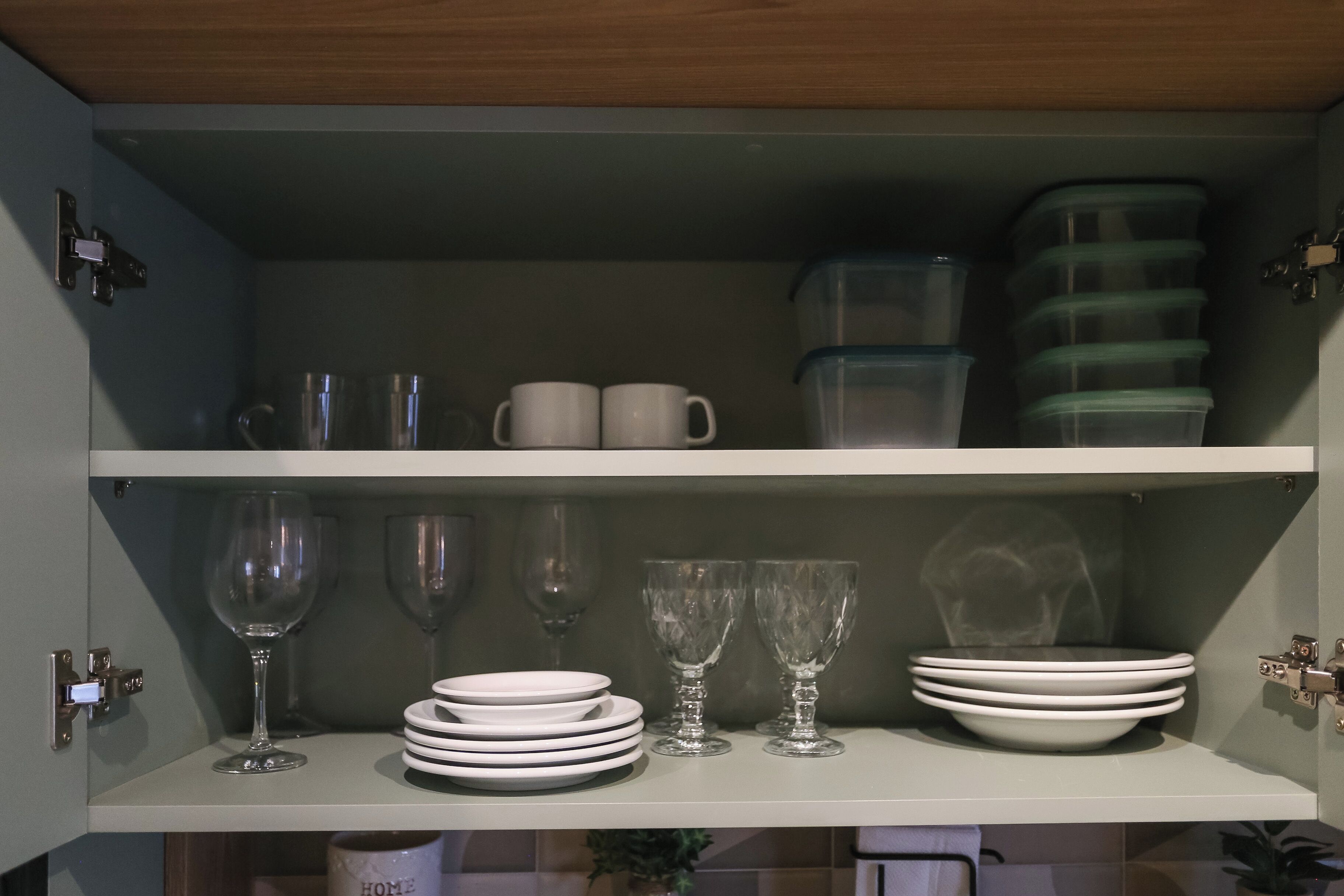 Ein Küchenschrank mit Regalen, voll mit verschiedenen Gläsern und Geschirr.