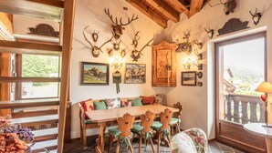 Un coin repas avec une table et des chaises en bois, agrémenté de décorations murales en forme de bois de cerf et de tableaux encadrés.