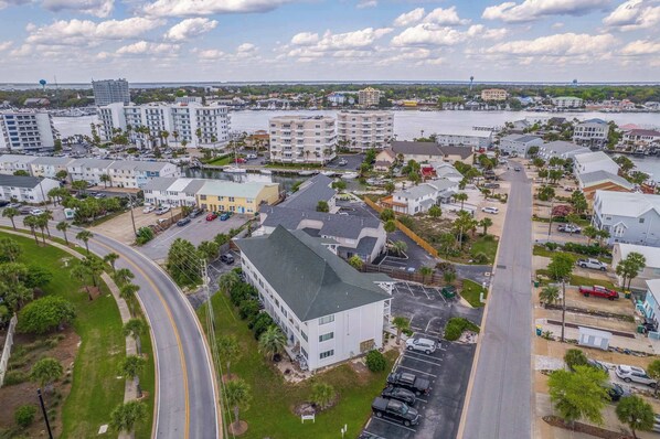 An aerial view of a coastal town with a marina, residential buildings, and a large body of water.
