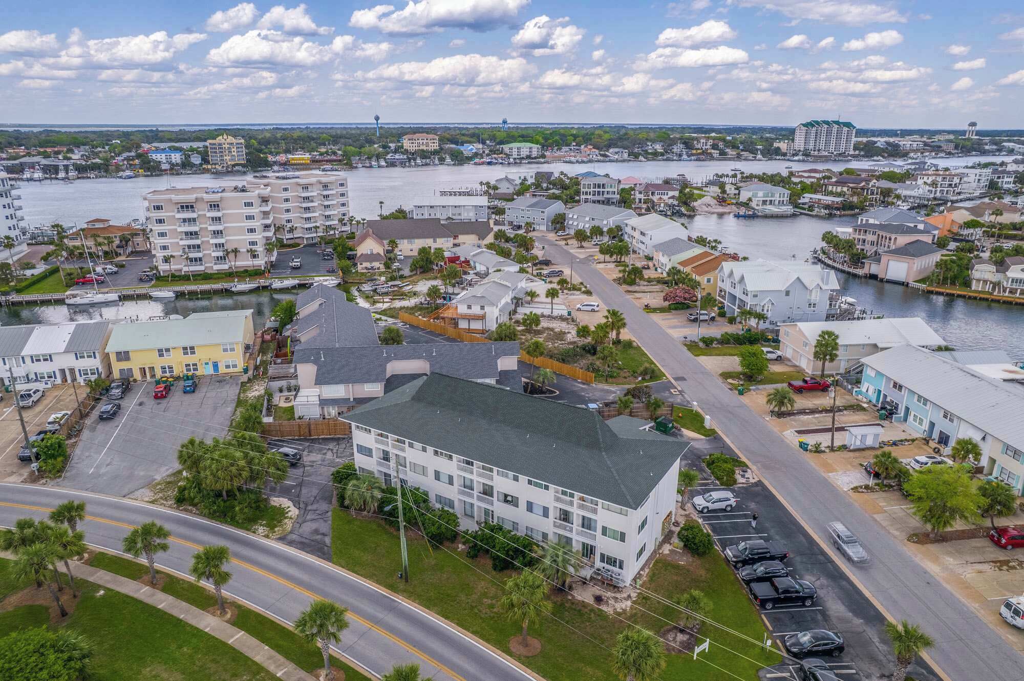 An aerial view of a coastal town with residential buildings, a marina, and a river.